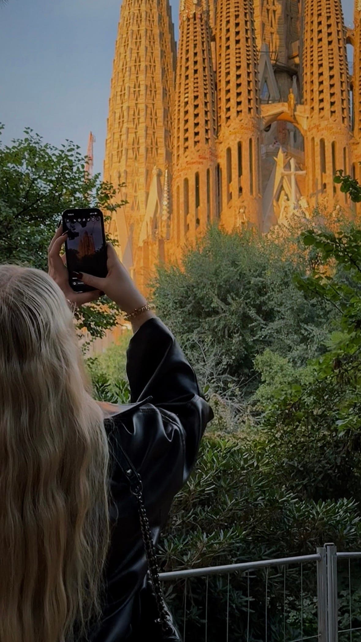 Mulher fotografando a Sagrada Família ao pôr do sol em Barcelona